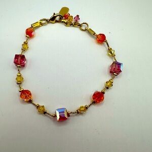 Dabby Reid pink and orange crystals with gold tone metal. 8” long